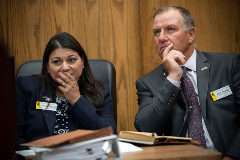 Reps. Rachel Rodriguez-Williams and Chip Neiman sit in court with their hands on their faces